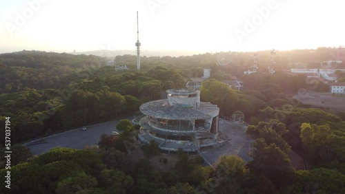 Aerial drone view of abandoned restaurant and viewpoint panoramic building in European art deco style the middle of Monsanto forest in Lisbon Portugal.