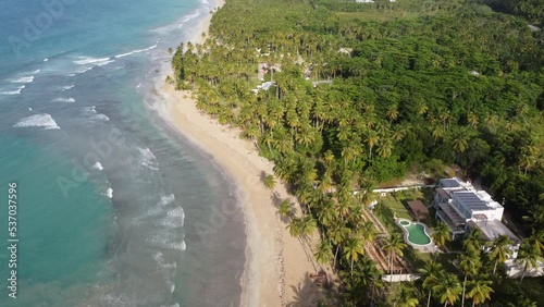 Aerial drone video of tropical paradise beach with blue waters, white sand and palm trees in Samana, Dominican Republic, Caribbean.