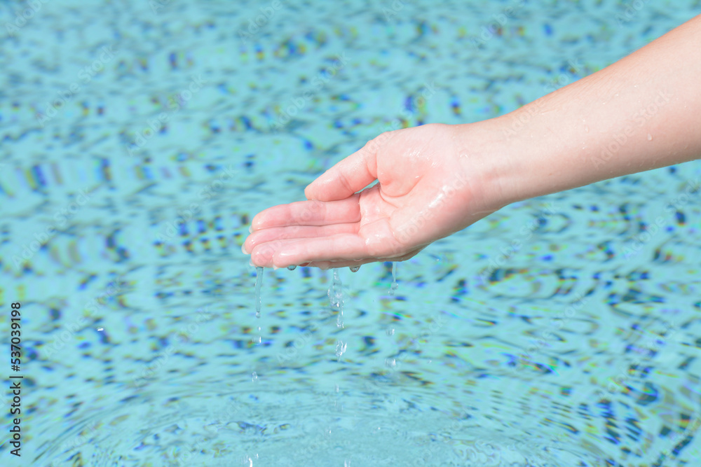 Girl pouring water from hand in pool, closeup Girl pouring water from hand in pool, closeup