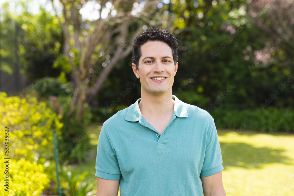 Portrait of young caucasian men wearing blue shirt and standing in the garden Portrait of young caucasian men wearing blue shirt and standing in the garden
