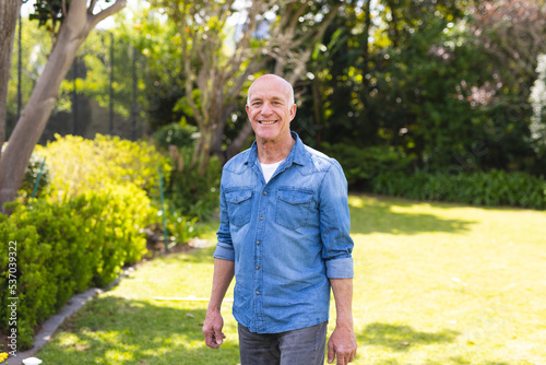 Tableau sur toile Portrait of senior caucasian men wearing blue shirt and standing in the garden