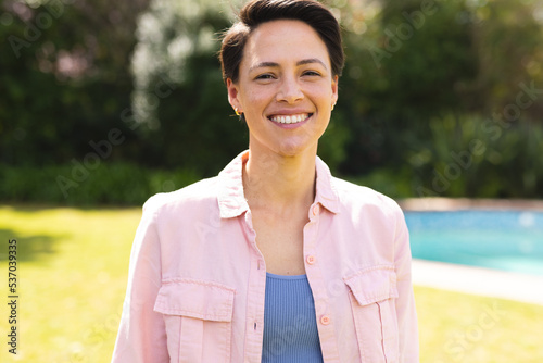 Portrait of young caucasian women wearing blue shirt and standing in the garden