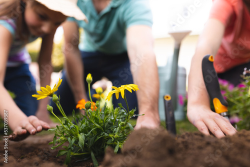 Caucasian family spending time together in the garden, planting