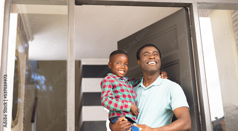 Fototapeta premium African american father and son welcoming some body outside the house