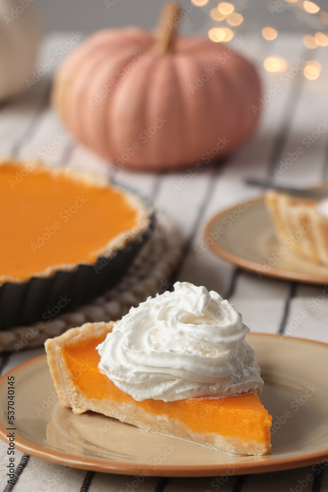 Piece of fresh homemade pumpkin pie with whipped cream on table Piece of fresh homemade pumpkin pie with whipped cream on table