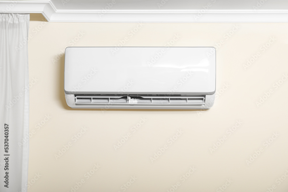 Modern air conditioner on white wall indoors