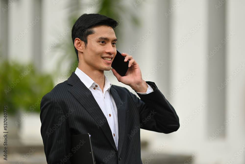 Smart Businessman talking on phone while out of the office. Smart Businessman talking on phone while out of the office.