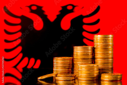 A stack of gold coins on the background of the flag of Albania . Country economy concept photo