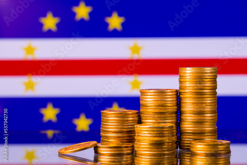 A stack of gold coins on the background of the flag of Cape Verde. Country economy concept
