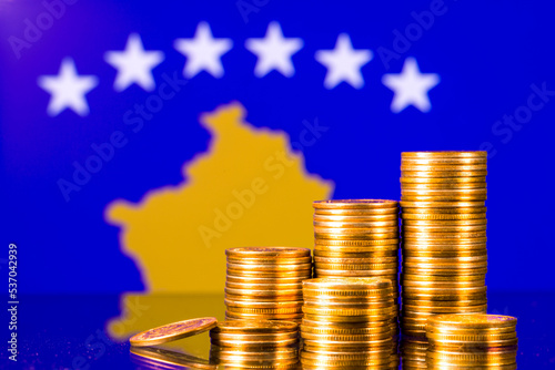 A stack of gold coins on the background of the flag of Kosovo . Country economy concept