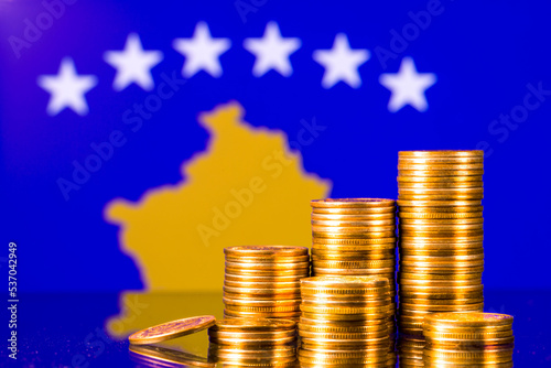 A stack of gold coins on the background of the flag of Kosovo. Country economy concept 