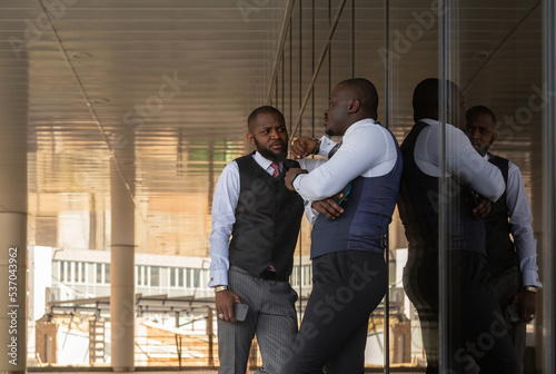 Portrait of two handsome african american businessman partner friends in suit against modern building exterior © xartproduction