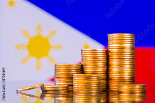 A stack of gold coins on the background of the flag of Philippines. Country economy concept