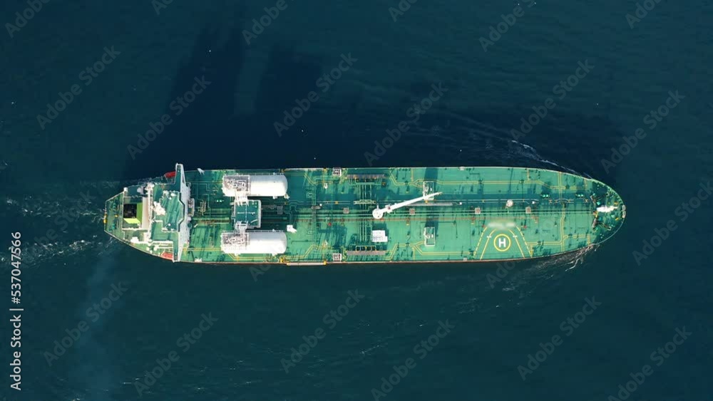Aerial drone top down: Gas tanker ship sail and transporting liquefied or compressed natural gas, CNG, LNG. Petrochemical tanker vessel cruising open sea