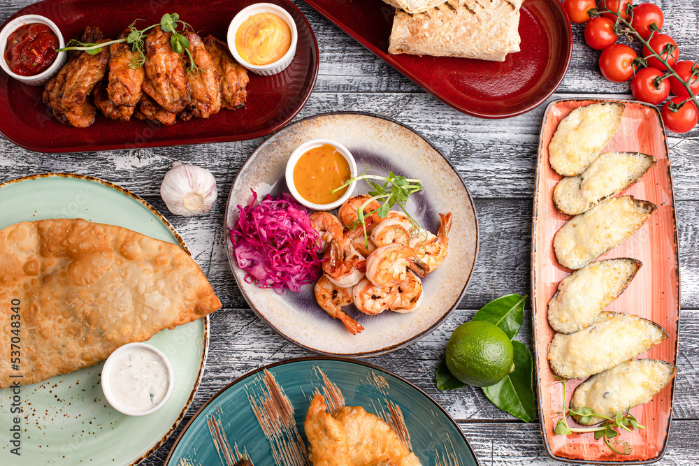 Table with various snacks, snacks for everyone on a wooden white background Table with various snacks, snacks for everyone on a wooden white background