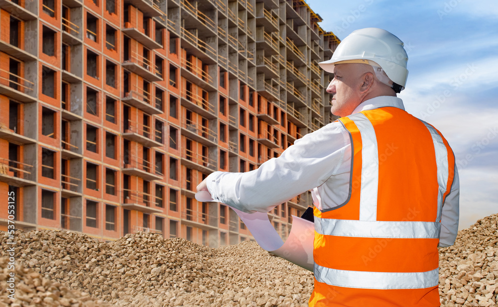 Construction multistorey building. Man builder stands with back to
