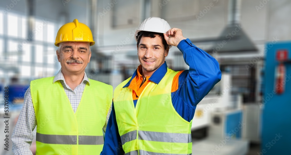 Young engineer worker with blueprint on big factory background. Young engineer worker with blueprint on big factory background.