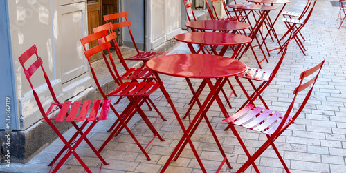 red tables with chairs of a street cafe