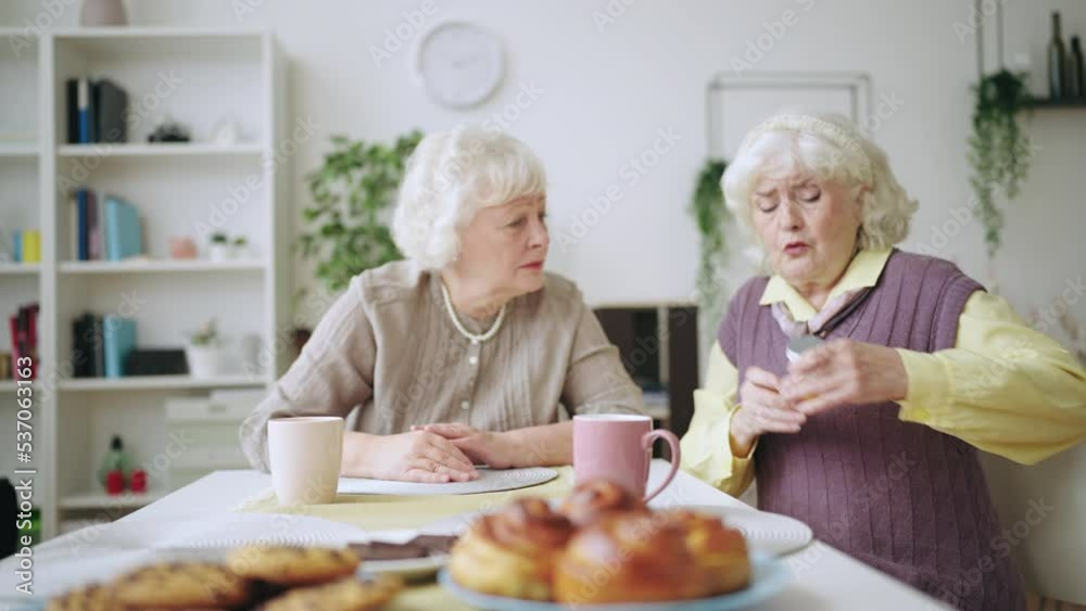 Senior woman recommending medication to her sister, friendly advice, healthcare Senior woman recommending medication to her sister, friendly advice, healthcare