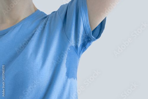 Sweat under the arm. Close-up of sweat stain on a blue t-shirt.