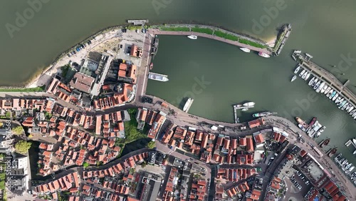 Volendam, Netherlands. Top down overview of traditional dutch fishing village city traditional buildings and harbor. Touristic attraction sky clouds and urban city layout. Aerial drone view. photo