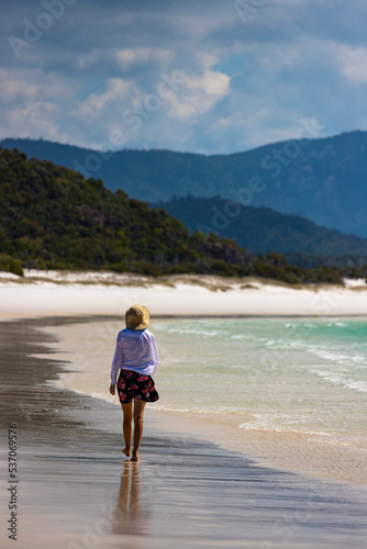 beautiful girl in dress and shirt and hat walks on paradise beach with white sand and turquoise water  walk on whitehaven beach on whitsunday island in queensland  paradise beaches of australia  sunny © Jakub