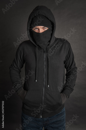 Unrecognizable man in the black hoody with hood wearing balaclava mask
