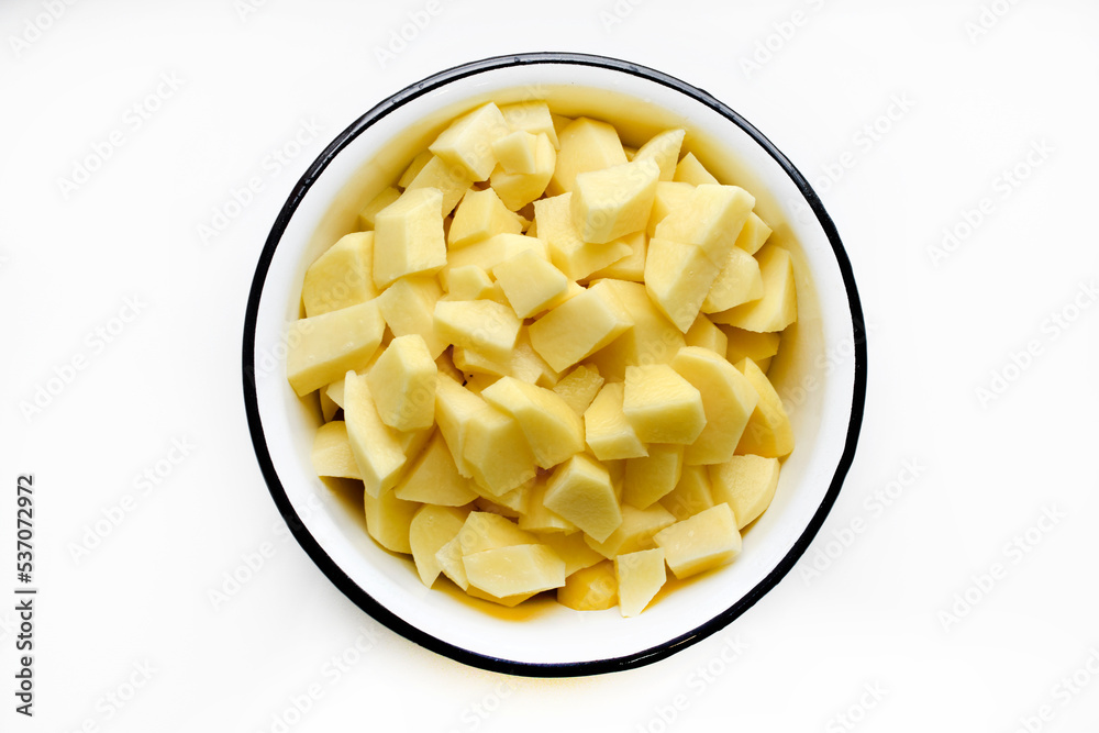 Fresh peeled potatoes in slices in a white dish on a white background. Delicious clean potatoes. Fresh peeled potatoes in slices in a white dish on a white background. Delicious clean potatoes.