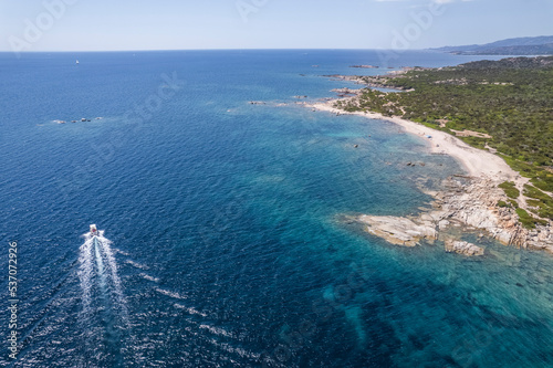 Aerial view of a small sailing boat navigating along the coastline, Figari, Corse, France. photo