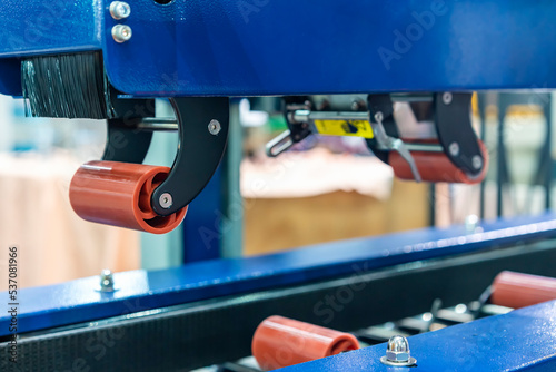 Close up upper urethane rubber roller and brush of automatic box carton sealing machine by masking tape for commercial packing industrial