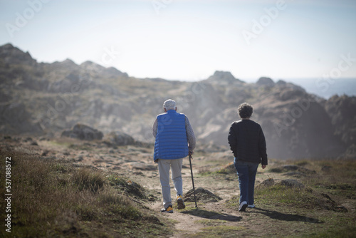 An elderly couple walks along the coast of Corrubedo by the sea photo