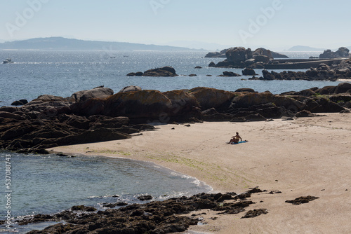 A person watches the sea at Gavoteira do Fontán beach, Riveira photo