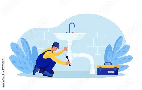 Repairman in uniform repairs ceramic sink, plumbing pipes with tool. Professional worker with wrench. Home masters, handyman fixing broken home plumbing. Electrician, plumber call. Repair service