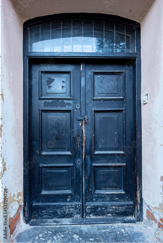 Stare drzwi, tekstura zniszczonego drewna, złuszczona farba.