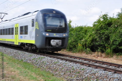 Eisenbahnschienen mit Triebwagenzug auf eingelsiger Strecke im Sommer 