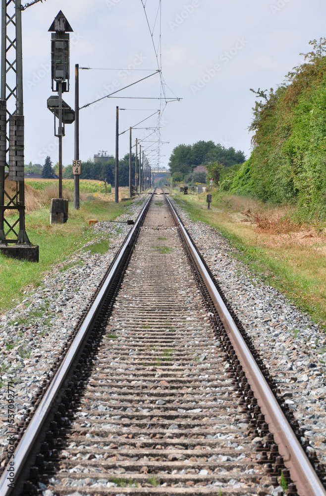 Eisenbahnschienen mit Triebwagenzug auf eingelsiger Strecke im Sommer 