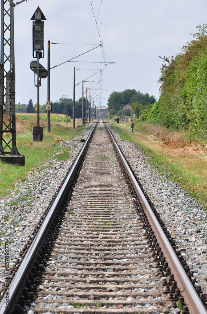 Eisenbahnschienen Mit Triebwagenzug Auf Eingelsiger Strecke Im Sommer eisenbahnschienen-mit-triebwagenzug-auf-eingelsiger-strecke-im-sommer