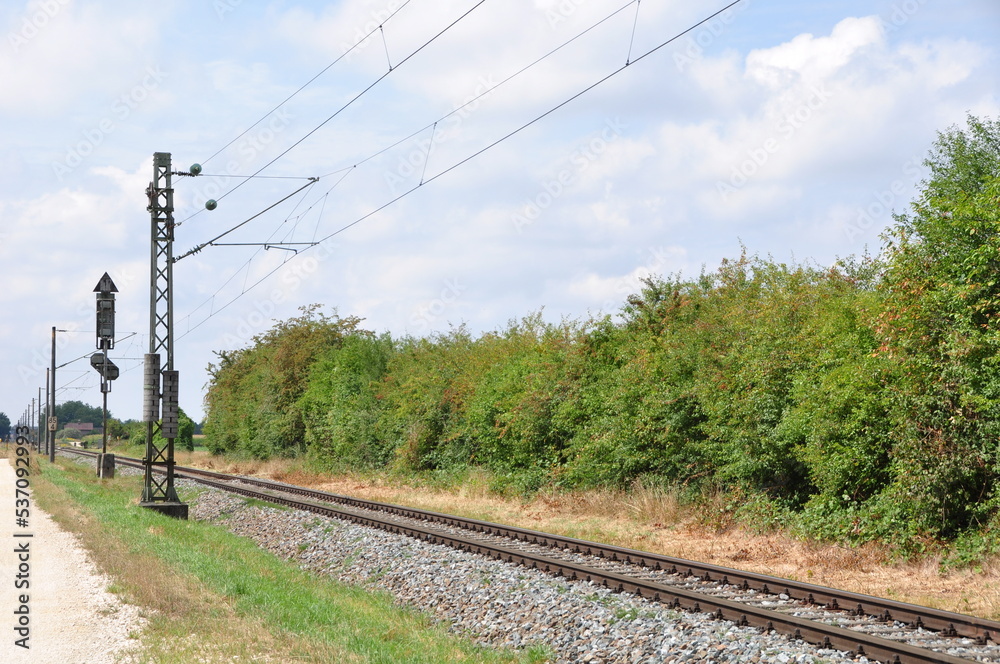 Eisenbahnschienen mit Triebwagenzug auf eingelsiger Strecke im Sommer ...