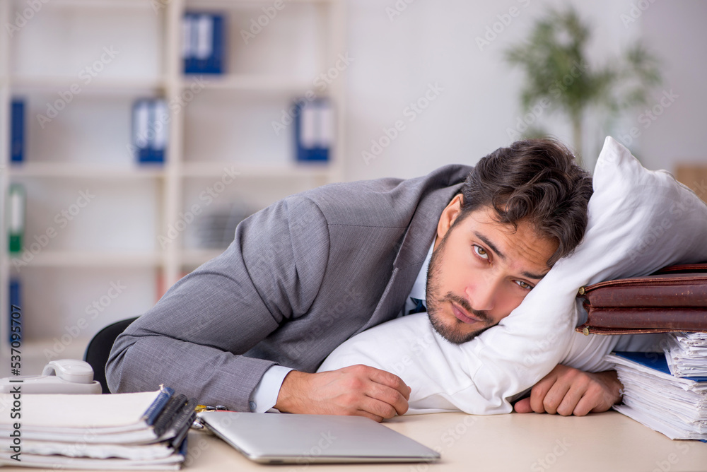 Young male employee in oversleeping concept Young male employee in oversleeping concept