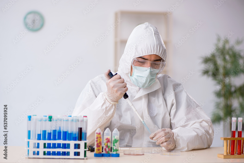 Young male chemist in drugs synthesis concept Young male chemist in drugs synthesis concept