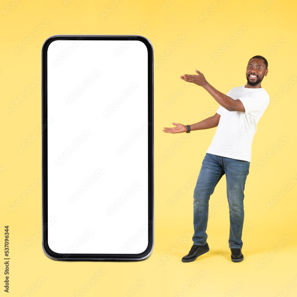 Black Guy Showing Big Smartphone With Blank Screen In Studio Black Guy Showing Big Smartphone With Blank Screen In Studio