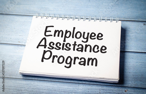 paper with the text EAP Employee Assistance Program on blue wooden background