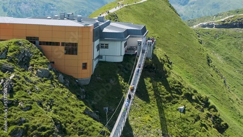 Suspension bridge in Gastein. Scary experience on the top of mountains and hills, abyss. Travel people walking crossing, sightseeing, hiking. Spring green mountain in background. Building in rocks (ID: 537100920)