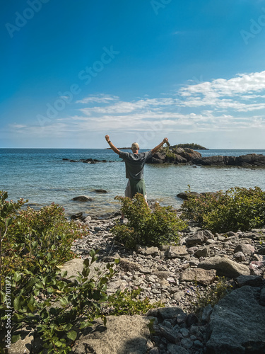 Single Athletic Hiker Rejoices at the Beauty of Nature and Reaching his Destination. Stunning views of wilderness and nature located within Isle Royale National Park in the Upper Peninsula of Michigan