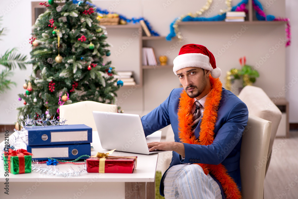 Young businessman working from home at Christmas eve Young businessman working from home at Christmas eve