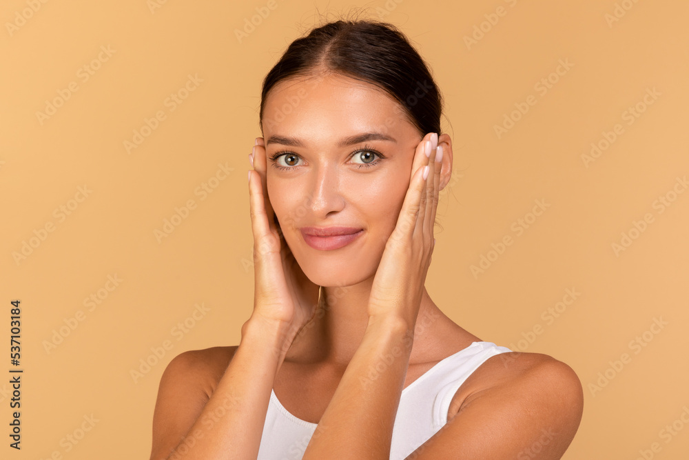 Essential beauty. Portrait of happy lady touching her smooth skin, looking at camera, enjoying result of beauty treatments Essential beauty. Portrait of happy lady touching her smooth skin, looking at camera, enjoying result of beauty treatments