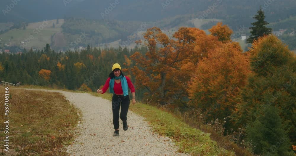 young woman traveler in the mountains enjoying the cool autumn weather and fooling around. autumn cold weather. Generation Z travel young woman traveler in the mountains enjoying the cool autumn weather and fooling around. autumn cold weather. Generation Z travel