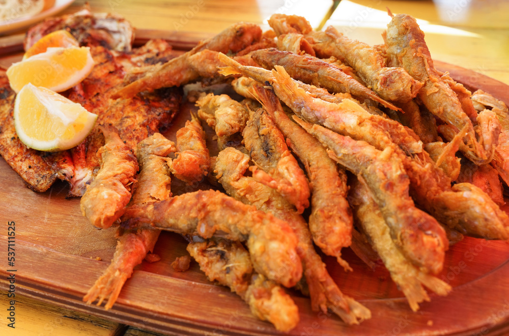 Plate of fried small fish red mullet and lemon