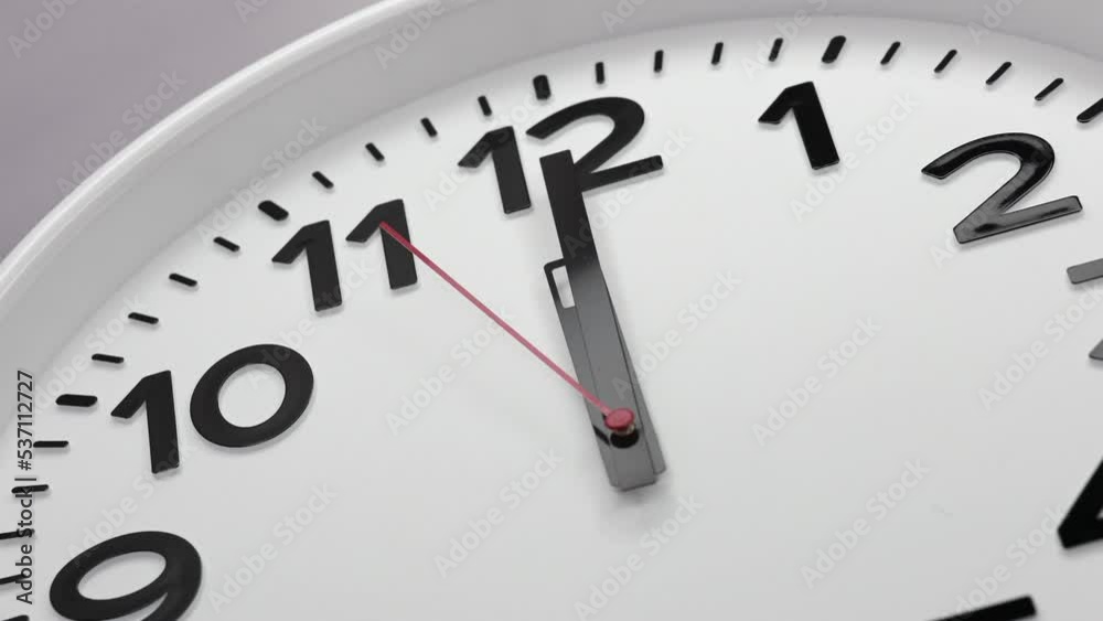A White Wall Clock With The Time Of 12.00 Am Or Pm. A Black Hands and Red Second Hand Of The Clock, The Concept Of Time. Timelapse. 60 FPS, 4k. ProRes. A White Wall Clock With The Time Of 12.00 Am Or Pm. A Black Hands and Red Second Hand Of The Clock, The Concept Of Time. Timelapse. 60 FPS, 4k. ProRes.