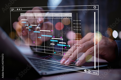 man using labtop , hand using laptop with virtual work schedule plan on screen photo
